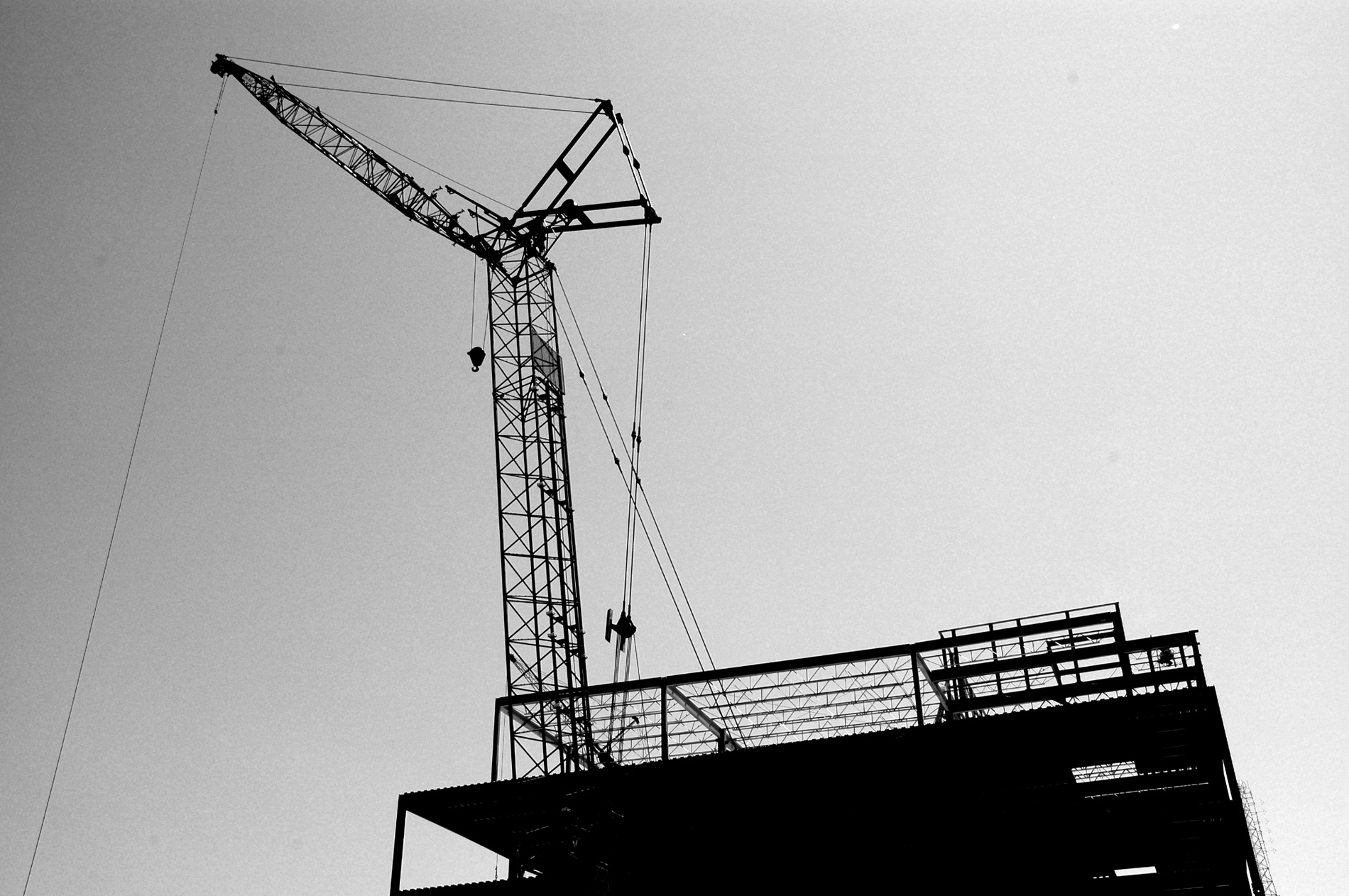 A crane during the day helping construction workers.
